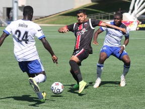 Ottawa Fury FC forward Aly Alberto Hassan protects the ball from two FC Edmonton defenders during NASL action in Fort McMurray Alta. on Sunday August 2, 2015. Robert Murray/Fort McMurray Today/Postmedia Network