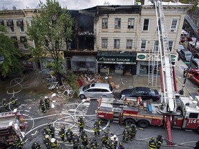 A firefighter respond to an apparent gas explosion and fire in the Brooklyn borough of New York, October 3, 2015. An apparent gas explosion and fire in New York on Saturday tore off a building facade and drew more than 100 firefighters to the scene, fire officials said. The New York City Fire Department was unable to confirm media reports that one person was killed and three others injured in the blast at a three-story structure in the borough of Brooklyn. REUTERS/Stephanie Keith