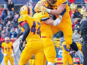 Queen's Gaels Jason Shamatutu, Luke McQuilkin and Mike Moore celebrate an end zone interception against the Gueph Gryphons during the first quarter of the Queen's home game at Richardson Stadium on Saturday, October 3, 2015. The Gaels beat the Gryphons 23 -15. Julia McKay/Kingston Whig-Standard/QMI Agency