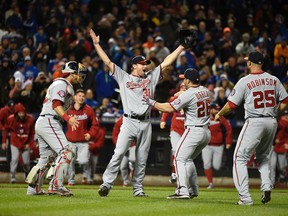 Washington Nationals starting pitcher Max Scherzer, second from left, celebrates his no hitter against the New York Mets with teammates, catcher Wilson Ramos (40), Dan Uggla (26), and Clint Robinson (25) in the second baseball game of a doubleheader, Saturday, Oct. 3, 2015, in New York. (AP Photo/Kathy Kmonicek)