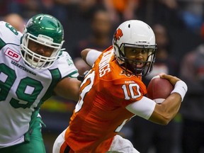 B.C. Lions QB Jonathon Jennings, right, runs from Saskatchewan Roughriders DL Andre Monroe during the first half of their CFL football game in Vancouver, B.C., on October 3, 2015. (REUTERS/Ben Nelms)