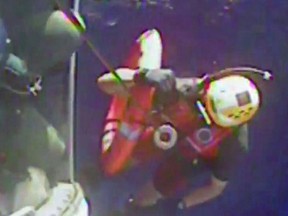 This still image from video taken October 4, 2015 by the US Coast Guard shows a Helicopter crew recovering a life ring from the El Faro cargo ship, that has gone missing during Hurricane Joaquin. Rescuers were still frantically searching for the El Faro cargo vessel, with which contact was lost early October 1 as the dangerous weather system approached the Bahamas. So far, coast guard staff have turned up a life ring from the missing boat, but had no information about the boat's fate, according to company officials who said searching would continue October 4. En route from Florida to Puerto Rico, the 735-foot (224-meter) cargo ship was reported to be caught in the storm near Crooked Island, part of the Bahamas island chain. (AFP PHOT /HANDOUT/US COAST GUARD)