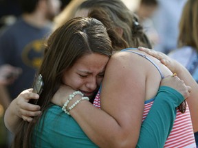 Jessica Vazquez, facing camera, hugs her aunt, Leticia Alcaraz, as they await word on Alcaraz's daughter after a deadly shooting at Umpqua Community College, in Roseburg, Ore., on Thursday, Oct. 1, 2015. (Andy Nelson/The Register-Guard via AP)