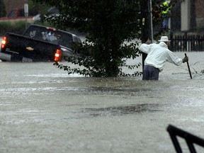 A vehicle and a man try to navigate floodwaters in Florence, S.C., Sunday, Oct. 4, 2015, as heavy rain continues to cause widespread flooding in many areas of the state. The rainstorm drenching the East Coast brought more misery to South Carolina, cutting power to thousands, forcing hundreds of water rescues and closing scores of roads because of floodwaters. (AP Photo/Gerry Broome)