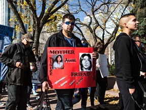People walk with signs during the Sisters in Spirit ninth annual Stolen Sisters and Brothers Awareness Walk from Sir Winston Churchill Square to the iHuman Youth Society in Edmonton, Alta. on Sunday, Oct. 4, 2015. The Stolen Sisters Awareness Movement was created in May 2007 to raise international awareness to the disproportionate number of missing and murdered Métis, Inuit, Non Status and First Nations women in Canada, according to the group's Facebook page. Codie McLachlan/Edmonton Sun/Postmedia Network