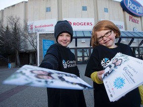 Liam Heffelfinger, 5, Cayleigh Bell, 5, and Grade 1 students from Crestwood School hand out flyers reminding hockey fans to bring donations for the United Way's Coats for Kids and Families campaign to the Dec. 13 Oil Kings game, outside Rexall Place, in Edmonton Alta. on Sunday Oct. 4, 2015. David Bloom/Edmonton Sun/Postmedia Network