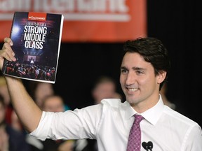 Liberal Leader Justin Trudeau holds up his party's platform at a press conference in Waterloo, Ont. on Monday, October 5, 2015. (THE CANADIAN PRESS/Paul Chiasson)