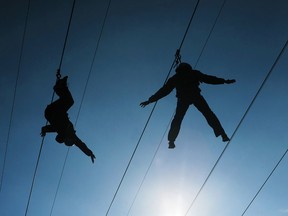 In this Feb. 2, 2012 file photo, zip line riders slide above Capitol Street in Indianapolis. (AP Photo/Jeffrey Furticella, File)