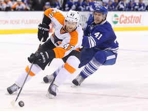 Philadelphia Flyers defenceman Andrew MacDonald skates with the puck as Toronto Maple Leafs left winger Nikolai Kulemin chases him at Air Canada Centre in Toronto on March 8, 2014. (Tom Szczerbowski/USA TODAY Sports)