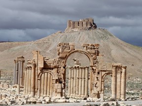 A file picture taken on March 14, 2014 shows the famous Arch of Triumph (front) and a partial view of the ancient oasis city of Palmyra, 215 kilometres northeast of the Syrian capital, Damascus. Islamic State extremists have blown up the famous Arch of Triumph in the ancient Syrian city of Palmyra, said an activist and monitoring group, as the jihadists press their campaign to tear down the treasured heritage site. (AFP PHOTO/JOSEPH EID)
