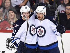 Winnipeg Jets center Andrew Copp (51) and defenceman Ben Chiarot (7) celebrate Chairot's goal against the  Calgary Flames during the second period at Scotiabank Saddledome. Candice Ward-USA TODAY Sports
