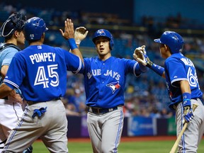 Toronto Blue Jays shortstop Darwin Barney (18) is congratulated by center fielder Dalton Pompey (45) and second baseman Munenori Kawasaki (66) as he hits a 2-run home run during the ninth inning against the Tampa Bay Rays at Tropicana Field. Tampa Bay Rays defeated the Toronto Blue Jays 12-3. Kim Klement-USA TODAY Sports