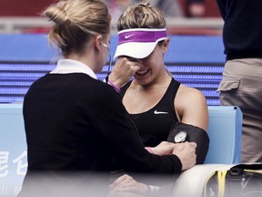 Eugenie Bouchard is treated after she was injured while playing against Andrea Petkovic of Germany at the China Open in Beijing, China, October 5, 2015. (REUTERS/Stringer)