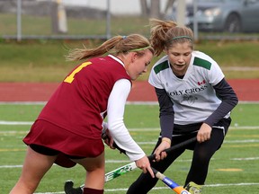 Regiopolis-Notre Dame Panthers’ Lilly Dickson, left, and Holy Cross Crusaders’ Jewel Neill battle for the ball during the 2014 high school girls field hockey final at the Invista Centre last October. Holy Cross is 5-0 this season and Regi is 4-0. (Whig-Standard file photo)