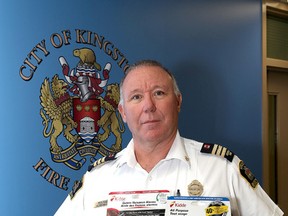 Paul Patry, assistant chief, fire prevention, holds a smoke detectors and a carbon monoxide detecter at Kingston Fire & Rescue Emergency Communications Centre on Monday. (Ian MacAlpine/The Whig-Standard)