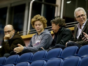 Oilers GM Peter Chiarelli, far left, watches practice from the stands while team owner Daryl Katz, centre, with his son Harrison, and former GM Craig MacTavish sit nearby. (Tom Braid, Edmonton Sun)