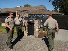 Sheriff's deputies stand in front of Snyder Hall at Umpqua Community College, Monday, Oct. 5, 2015, in Roseburg, Ore. The campus reopened on a limited basis for faculty and students for the first time since armed suspect Chris Harper-Mercer killed multiple people and wounded several others on Thursday before taking his own life at Snyder Hall. (AP Photo/John Locher)