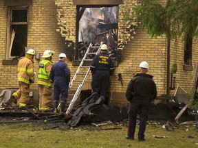 An investigator from the Ontario Fire Marshal?s office surveys the damage Monday after a farmhouse fire on Melbourne Road just west of Strathroy forced a family to flee for their lives. A 10-year-old boy is still missing. (MIKE HENSEN, The London Free Press)