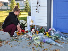 Fort Saskatchewan resident Bailey Dunbar pays her respects on Monday at a memorial outside the home of Colleen Sillito, who was killed on Friday. Omar Mosleh/Fort Saskatchewan Record/Postmedia Network