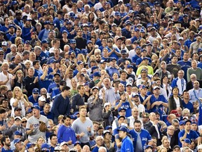Toronto Blue Jays fans stand on their feet cheering as the Jays play against the New York Yankees during seventh inning AL baseball action in Toronto on Wednesday, September 23, 2015. Sick days, last-minute vacation requests and reluctant ticket sales — those were just some of the options being considered by Toronto Blue Jays fans as the baseball team's long-awaited playoff games were officially slated for inconvenient afternoon starts. THE CANADIAN PRESS/Nathan Denette