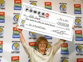 Powerball winner Julie Leach, of Three Rivers, Mich., holds a ceremonial check during a news conference at lottery headquarters in Lansing, Mich., Tuesday, Oct. 6, 2015. Leach won $310.5 million in the Sept. 30 drawing. She took a one-time lump payment of $197.4 million, about $140 million after taxes. (Danielle Duval/Jackson Citizen Patriot via AP)