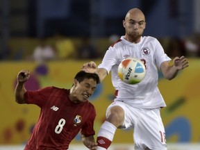 Jeremy Gagnon-Lapare (R) of Canada jumps for the ball next to Pedro Jeanine of Panama, during the first round group A football match of the Pan American Games  in Hamilton, Canada, on July 16, 2015.  AFP PHOTO / OMAR TORRES