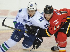 Stuart Dryden/Postmedia
Former Wolves player and Vancouver Canuck Frank Corrado battles for the puck with Matt Stajan of the Calgary Flames during a pre-season game last September. He has now been picked up off waivers by the Toronto Maple Leafs.