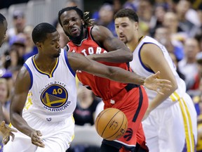 Warriors’ Harrison Barnes (left) strips the ball from the Raptors’ DeMarre Carroll on Monday night. Carroll has been excellent in the first two pre-season games.  (AP photo)