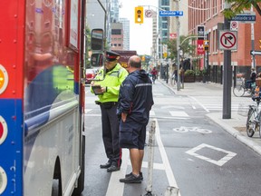 Const. Clint Stibbe tickets a Canada Post delivery vehicle during a parking enforcement blitz targeting congestion in downtown Toronto Monday October 5, 2015.  (Ernest Doroszuk/Toronto Sun)
