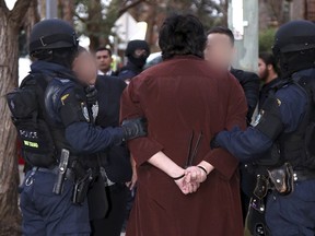 Police officers detain a man during early morning raids in western Sydney, Australia, on Oct. 7, 2015, in this handout courtesy of New South Wales (NSW) Police. Australian counterterrorism police investigating the shooting death of police accountant Curtis Cheng are questioning four people arrested on Wednesday in raids in Sydney. (REUTERS/NSW Police/Handout via Reuters)