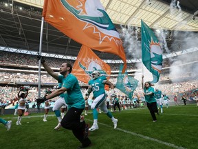 The Miami Dolphins run onto the field for the NFL football game between the New York Jets and the Miami Dolphins and at Wembley stadium in London, Sunday, Oct. 4, 2015. (AP Photo/Tim Ireland)