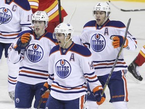 Edmonton Oilers Jordan Eberle #14, Ryan Nugent-Hopkins #93 and Taylor Hall #4 celebrate a second period goal against the Calgary Flames in NHL action on January 26, 2013 at the Scotiabank Saddledome in Calgary, Alberta, Canada.   Mike Ridewood/Getty Images/AFP