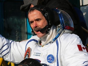 International Space Station crew member Canadian astronaut Chris Hadfield waves as he boards the Soyuz TMA-07M spacecraft at the Baikonur cosmodrome December 19, 2012.  REUTERS/Dmitry Lovetsky/Pool