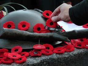 People lay poppies on the tomb of the unknown soldier at the National War Memorial to mark Canada's observance of Remembrance Day in Ottawa on Tuesday Nov 11,  2014.  Tony Caldwell/Ottawa Sun files