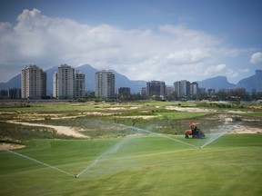 In this March 25, 2015 file photo, a worker cuts the grass on the Olympic golf course in Rio de Janeiro, Brazil. (AP Photo/Felipe Dana, File)