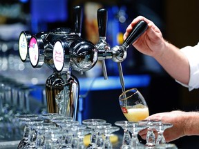 A waiter serves a glass of beer ahead of an Anheuser-Busch InBev shareholders meeting in Brussels in this April 30, 2014 file photo. REUTERS/Yves Herman/Files