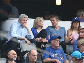 Canadian Prime Minister Stephen Harper watches the Toronto Blue Jays MLB game against the Cleveland Indians with his wife and son on August 31, 2015 at Rogers Centre in Toronto, Ontario, Canada.  Tom Szczerbowski/Getty Images/AFP