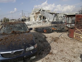 People inspect a site hit by what activists were cluster bombs dropped by the Russian air force in Maasran town, in the southern countryside of Idlib, Syria October 7, 2015. REUTERS/Khalil Ashawi