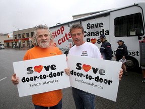 Dave Bleakney, left, second national vice-president of the Canadian Union of Postal Workers, with Brian Hackett, vice-president of the Kingston Local 556, on Clarence Street in front of main Kingston post office with the Save Canada Post recreational vehicle that is currently travelling across Canada.  (Ian MacAlpine /The Whig-Standard)