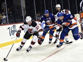 New Jersey Devils centre Pavel Zacha tries to drive the puck away from New York Islanders center John Tavares and defenceman Scott Mayfield as Devils right winger Kyle Palmieri follows during the third period of an NHL preseason game Sept. 23 in New York. Zacha played in four preseason games with the Devils before being returned to the Sarnia Sting Tuesday. (AP Photo/Kathy Kmonicek)