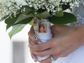 This July 5, 2015 photo provided by Lauren Chertok shows Chertok holding her bouquet on her wedding day. A photo of Chertok's late Aunt Rosie Van Acker is pinned to her bouquet. (Barattini Productions/Lauren Chertok via AP)