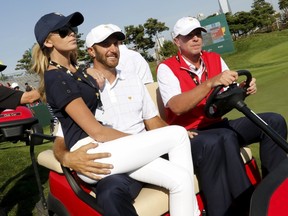Dustin Johnson rides on a golf cart with his fiance, Paulina Gretzky, after he and teammate Jordan Spieth defeated International team’s Danny Lee of New Zealand and Marc Leishman of Australia during the opening foursome matches of the Presidents Cup at the Jack Nicklaus Golf Club in Incheon, South Korea, October 8, 2015. (REUTERS/Toru Hanai)