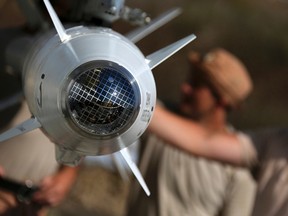 In this photo taken from Russian Defense Ministry official web site on Tuesday, Oct. 6, 2015,  Russian military support crew inspect missiles attached to their jet at an air base in Syria. at an air base Hmeimim in Syria. A spokeswoman for the Russian foreign ministry has rejected claims that Russia in its airstrikes in Syria is targeting civilians or opposition forces. (Russian Defense Ministry Press Service via AP)