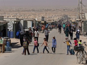 In this Thursday, Oct. 1, 2015, photo, Syrian refugees stroll on the main street of the UN-run Zaatari refugee camp near Mafraq, northern Jordan. More than four million Syrians fled civil war in their country, now in its fifth year. Most settled in Turkey, Lebanon and Jordan. Banned from working legally, they depend on aid and odd jobs. 
Raad Adayleh/The Associated Press