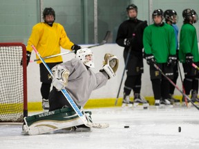 Teammates watch as London Jr. Knights minor midget AAA goalie Jukka Schotter makes a save during a team practice at the Western Fair Sports Centre in London Thursday. (CRAIG GLOVER, The London Free Press)