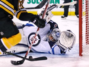 Winnipeg Jets goalie Ondrej Pavelec drops to the ice to make a save against the Boston Bruins during the second period of an NHL hockey game in Boston, Thursday, Oct. 8, 2015. (AP Photo/Charles Krupa)