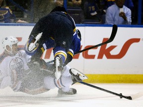 Blues defenceman Alex Pietrangelo trips over Oilers forward Matt Hendricks behind the St. Louis net during Thursday's game in St. Louis. (AP Photo)