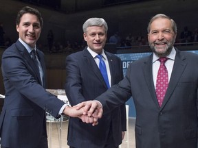 Liberal leader Justin Trudeau, left to right, Conservative leader Stephen Harper and NDP leader Thomas Mulcair join hands prior to the Munk Debate on foreign affairs, in Toronto, on Sept. 28, 2015. (REUTERS/Nathan Denette/Pool)