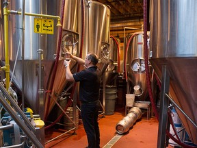 Brewmaster Joel Manning draws a sample of beer from a vat in the Mill Street Brewery in Toronto on Friday, Oct. 9, 2015. Labatt Breweries of Canada have announced it's purchase of the Mill Street Brewery, a craft brewery based in Toronto. THE CANADIAN PRESS/Chris Young