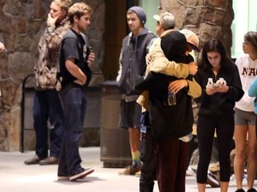Students embrace outside a hospital emergency room in Flagstaff, Ariz., on Friday, Oct. 9, 2015, after an early morning fight between two groups of college students escalated into gunfire, authorities said. (Jake Bacon/Arizona Daily Sun via AP)